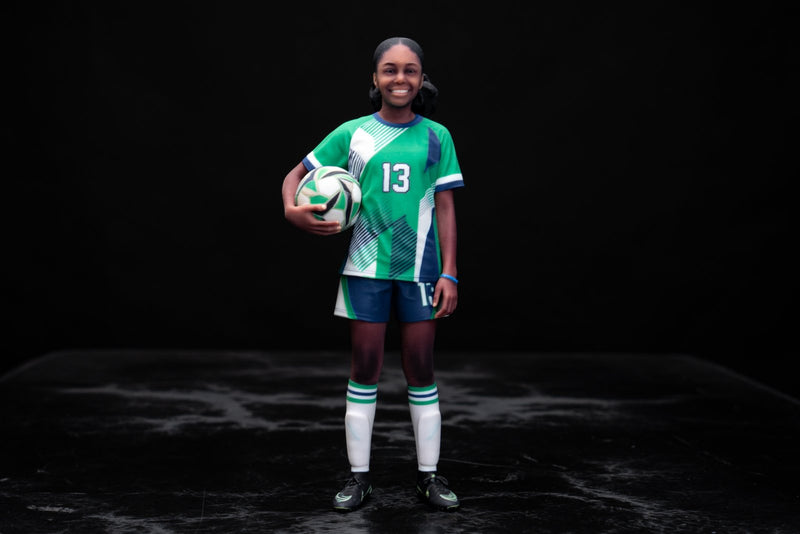 Full-color 3D printed figurine of a girl in a green soccer uniform holding a ball